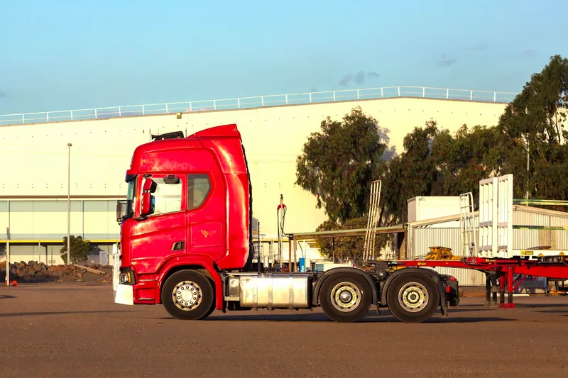 Rode trekker met een containerchassis op een bedrijventerrein